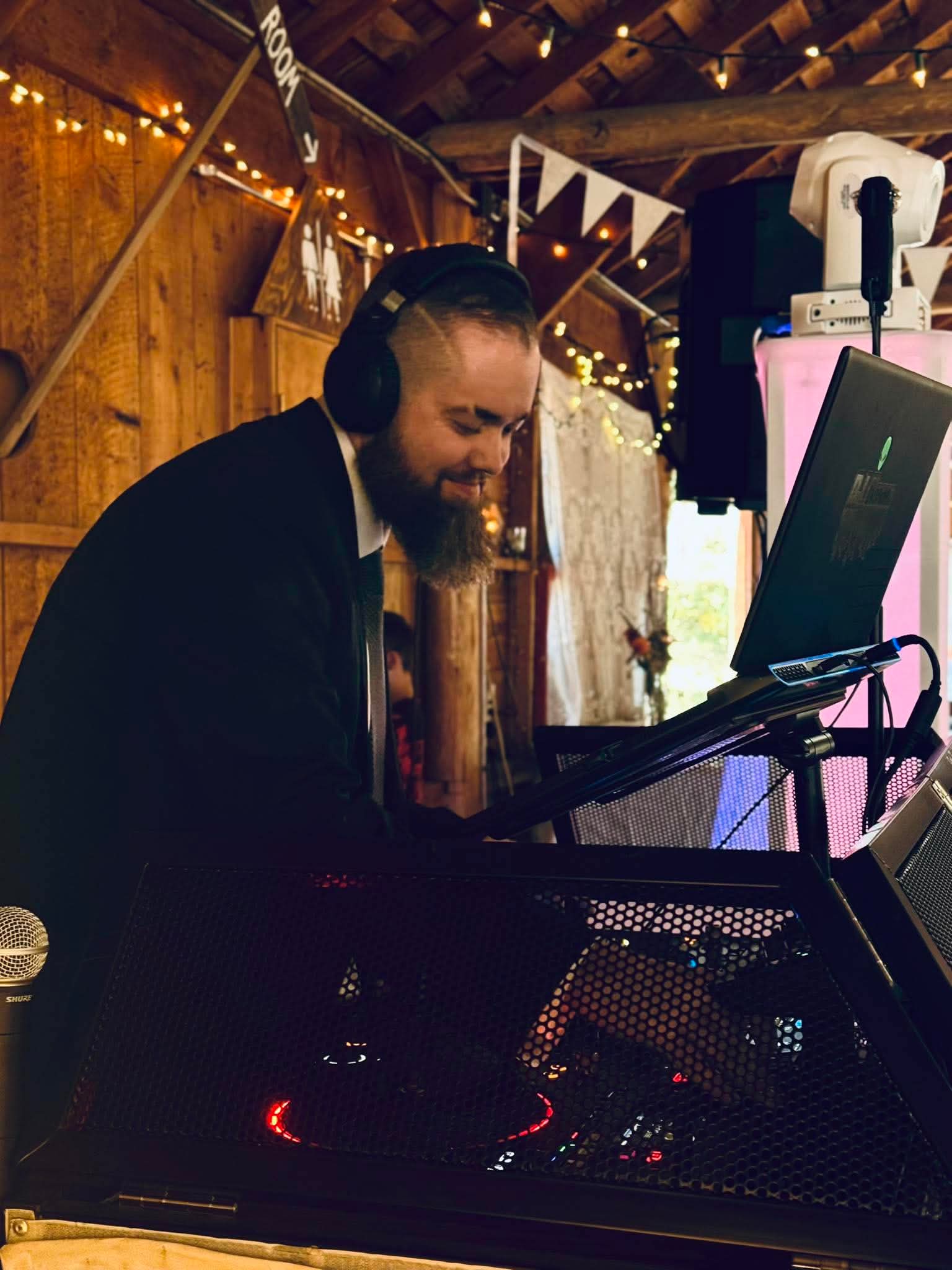 DJ Koma behind the decks at a barn reception